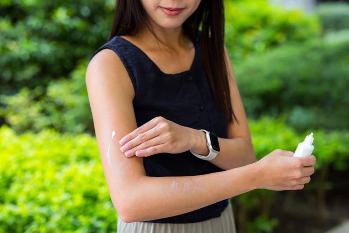 ผู้หญิงกำลังทาครีมบำรุงหรือครีมกันแดดที่แขน